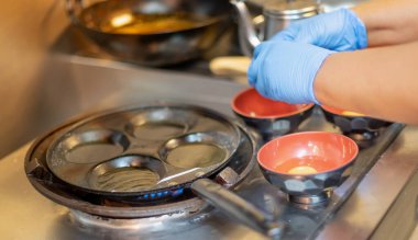 Şef cerrahi eldiven takıyor ve kızarmış yumurta pişiriyor Covid-19 salgınından dolayı yemek kutusuyla birlikte eve götürülüyor..