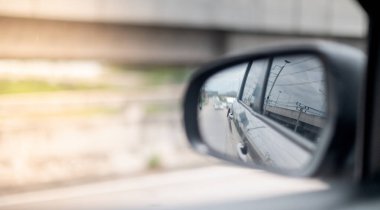 Yoldaki siyah araba görüntüsünün yanında ekspres yolda, sürücü ilk güvenlik için aynaya bakarken şeridi hareket ettirmek istiyor..