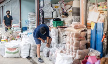 BANGKOK, THAILAND - 24 Ağustos 2021: İki işçi ağaç pazarındaki müşterilere satmak için toprak torbası hazırlayın.