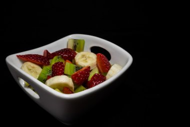 Karanlık bir arka plan üzerinde meyve kase