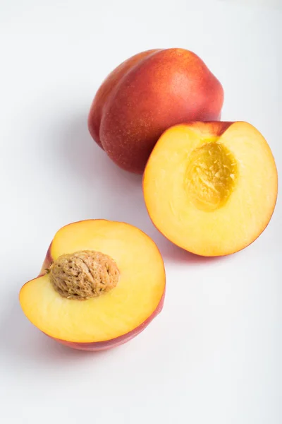 Nectarines cut in half over white background — Stock Photo, Image