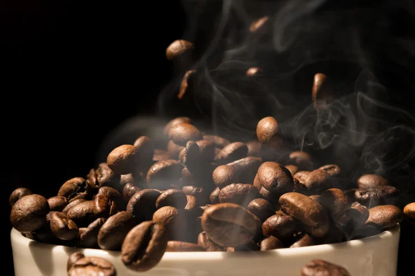 Coffee mug full of coffee beans with smoke — Stok fotoğraf