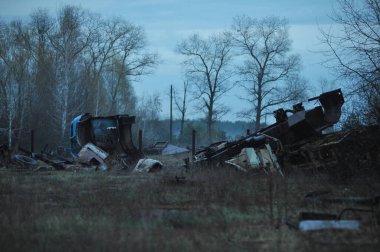 Çernobil 'deki araç mezarlığı terk edilmiş Kopachi köyü yakınlarındaki paslı radyoaktif makineler, kıyamet sonrası Ukrayna' nın uzak bölgesinde bahar mevsimi.