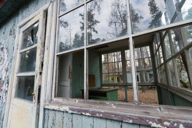 Genç Pioneer kampı Emerald 'daki terk edilmiş evin kırık penceresi, eski radyoaktif Sovyet tatil köyü, Çernobil Yasaklama Bölgesi, Ukrayna yaz sezonu.