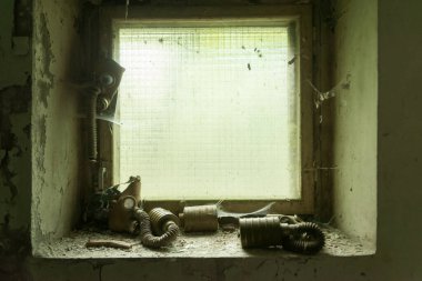 Hayalet şehir Pripyat 'ta radyoaktif gaz maskeli eski kirli pencere çerçevesi Çernobil Yasaklama Bölgesi, Ukrayna