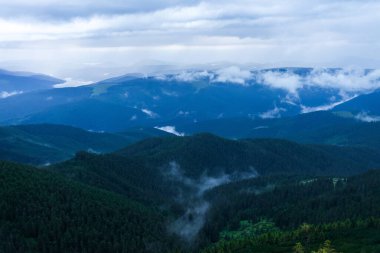 Yağmurlu günlerde bulutlu mavi dağlar, Ukrayna 'daki Karpat Dağları' nda hava durumu. Doğa manzarası arka planı