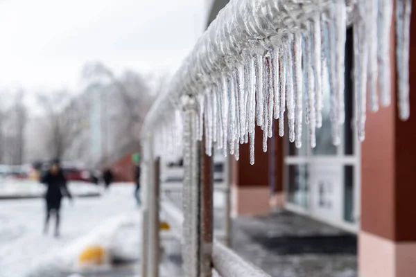 Belos icicles pendurados nos trilhos cromados da cidade perto dos escritórios. Fundo desfocado. — Fotografia de Stock