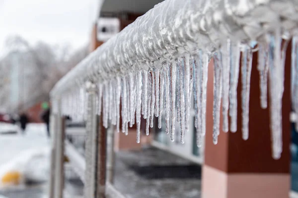 Belos icicles pendurados nos trilhos cromados da cidade perto dos escritórios. Fundo desfocado. — Fotografia de Stock