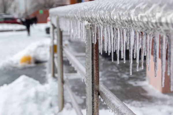 Belos icicles pendurados nos trilhos cromados da cidade perto dos escritórios. Fundo desfocado. — Fotografia de Stock