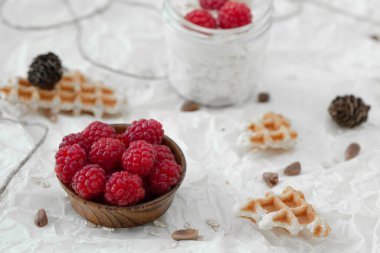 Ahududulu, müsli ve waffle 'lı süzme peynir, yoğurdun üstünde beyaz, sıcak bir kazağa sarılmış vaziyette..