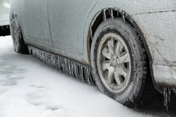 El coche gris de pasajeros estaba cubierto con una gruesa corteza de hielo después de la lluvia húmeda en la ciudad en invierno. Grande. — Foto de Stock