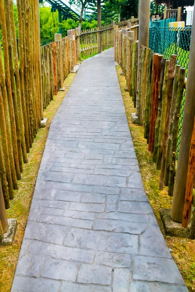 Loopbrug bakstenen in de tuin met groen gras — Stockfoto