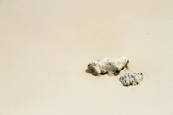 Recifes rochas na areia praia fundo . — Fotografia de Stock