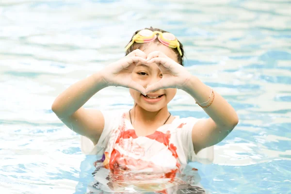 Girl in swimming pool with handmade heart shape — Stock Photo, Image