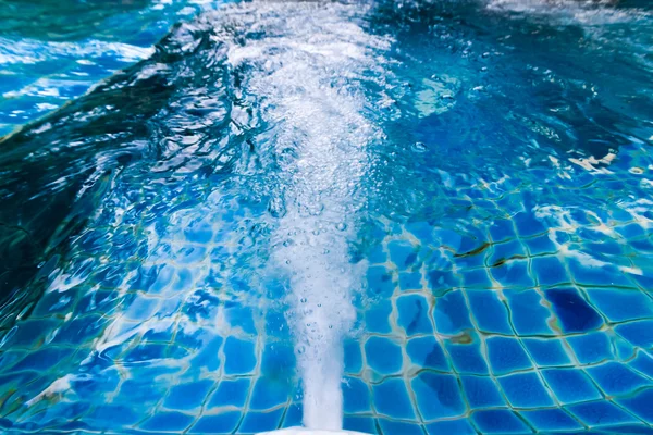 Agua saliendo del agujero cerca de la pared de la piscina . — Foto de Stock