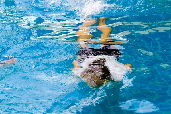 Unerkennbares junges Mädchen mit dem Gesicht nach unten im Schwimmbad. — Stockfoto