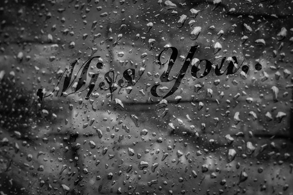 missing you text on water drops on glass window in raining Seaso