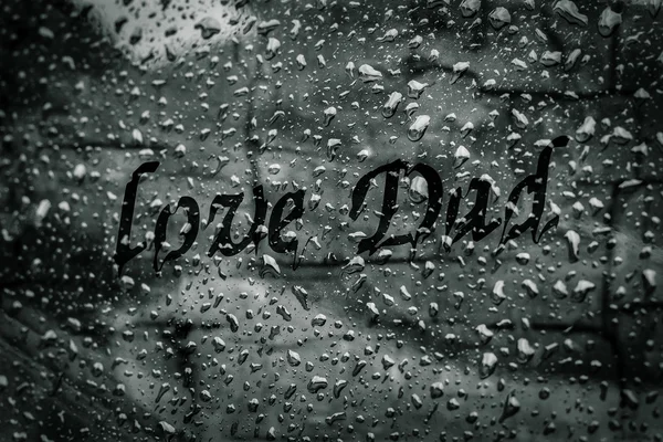 Amor pai texto em gotas de água na janela de vidro na estação chuvosa — Fotografia de Stock