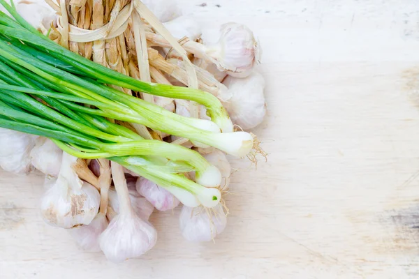 Zwiebeln und Knoblauch auf einem Holzboden — Stockfoto