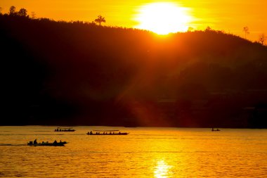 gün batımı tekne nehir san çalışan ile dağın arkasında