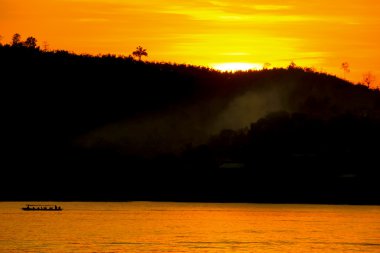 gün batımı tekne nehir san çalışan ile dağın arkasında