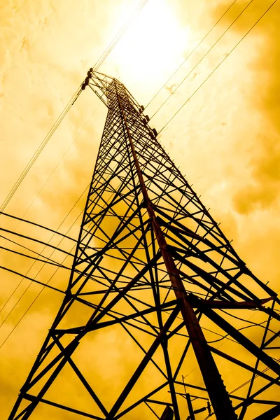 Energy power concept: high voltage pylons with cloud and sun bac Royalty Free Stock Photos