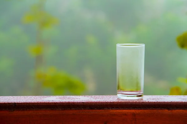 Wasserglas und Blumentopf auf dem Holzdeck. — Stockfoto
