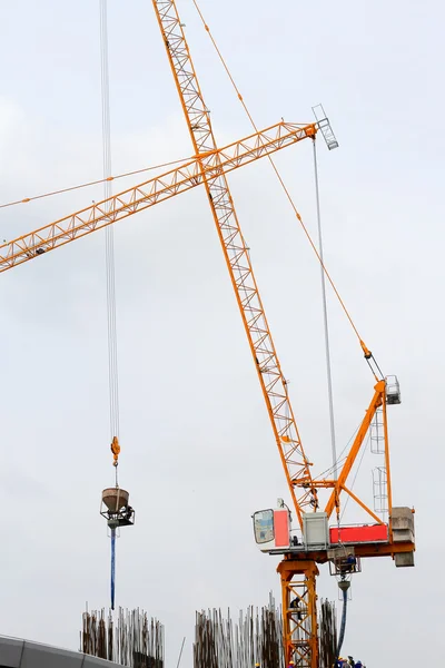 Toren kraan en werknemer gieten van beton op de werf — Stockfoto