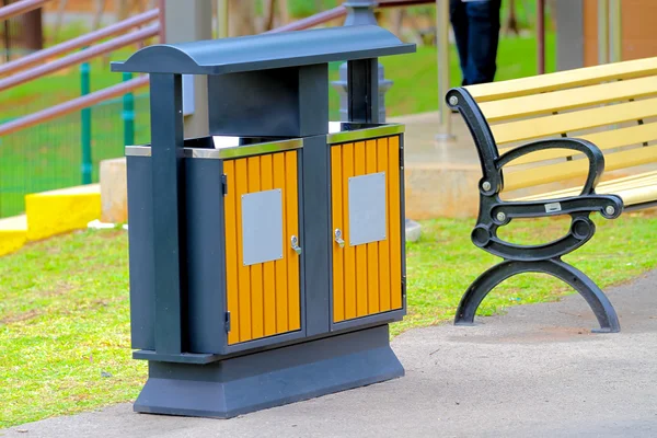 Basura o cubo de basura sentado en el pavimento de un parque natural —  Fotos de Stock