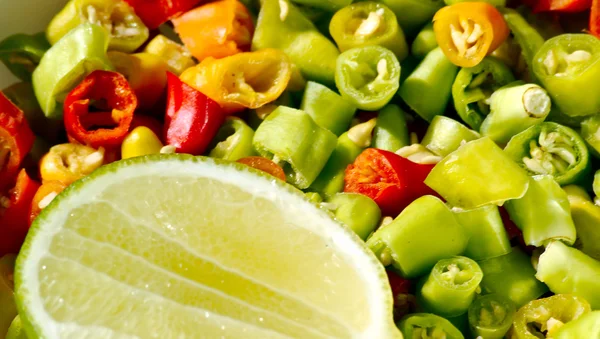 Close up of green chili pepper cut in pieces with lemon — Stock Photo, Image