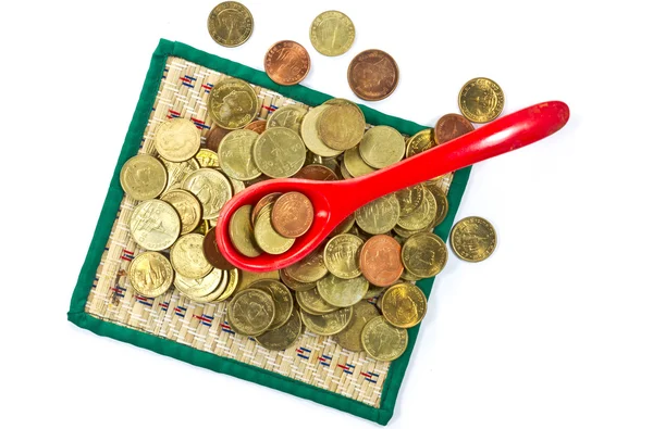 Coins inside red spoon on white background — Stock Photo, Image