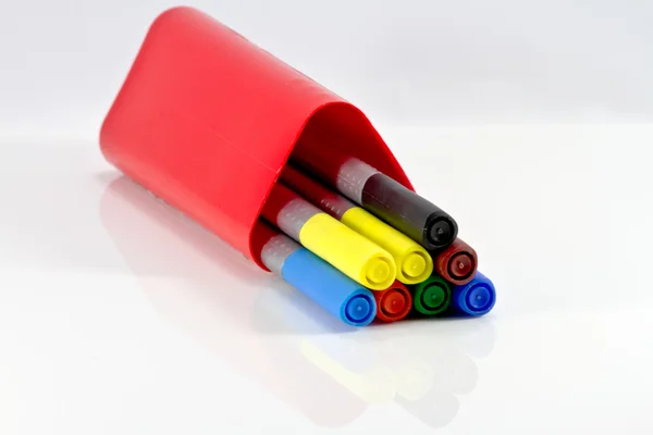 Varas coloridas em uma caixa vermelha em um fundo de mesa branca . — Fotografia de Stock
