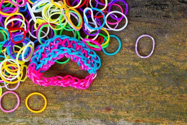 Colorful Rainbow loom bracelet rubber bands fashion on old wood — Stock Photo, Image