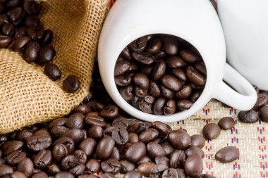 Kahve çekirdekleri ve bir fincan kahve tam kapat