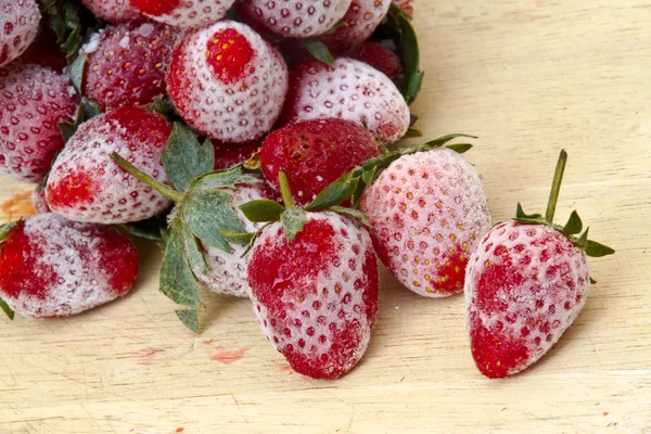 Çilek Çilek bir ahşap zemin üzerinde yerleştirilen dondurulmuş.