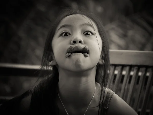 Mladá dívka se legrační obličej zároveň mít svačinu soubory cookie — Stock fotografie
