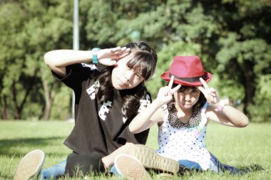 çimlerde oturan iki genç kız