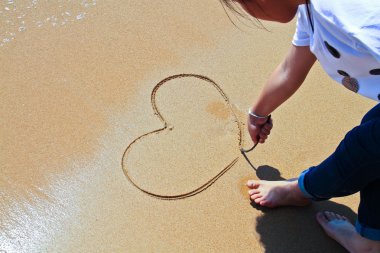 Sahilde bir kalp yazmak.