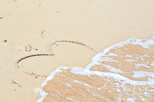 Water wave splash on heart shape draw on beach — Stock Photo, Image