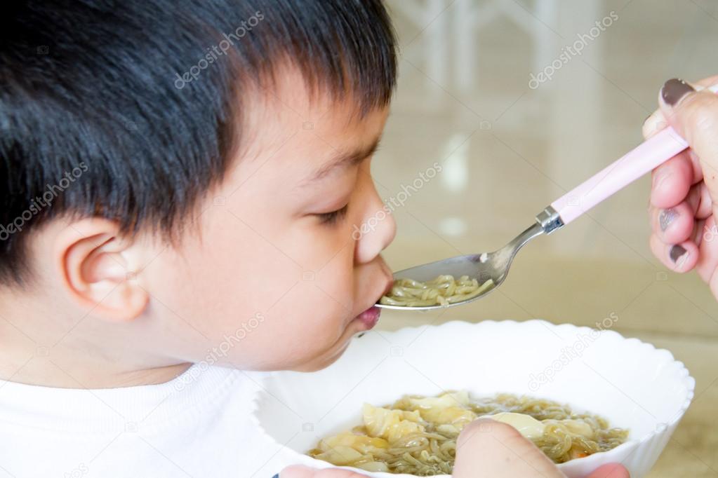Close up of South East Asian Thai baby  being spoon fed : being