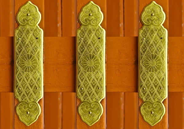 Hermosos patrones en una placa de latón fijar en madera de color rojo — Foto de Stock