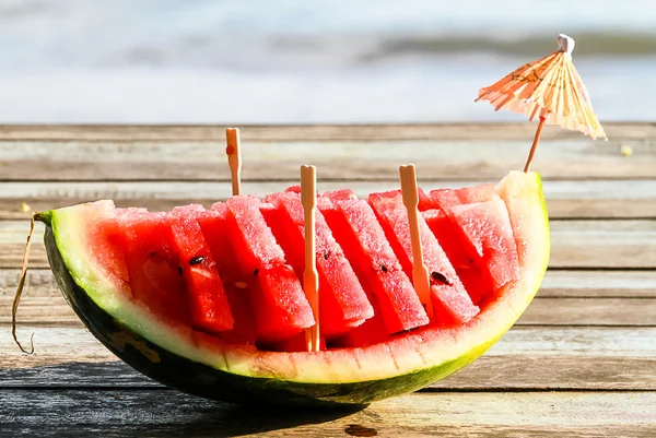 Nahaufnahme einer Wassermelone auf einem Holztisch am Meer. — Stockfoto