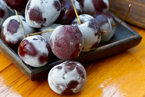 Bagas de cereja congeladas na mesa de madeira — Fotografia de Stock