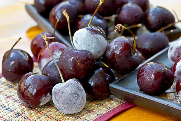 Bagas de cereja congeladas na mesa de madeira — Fotografia de Stock