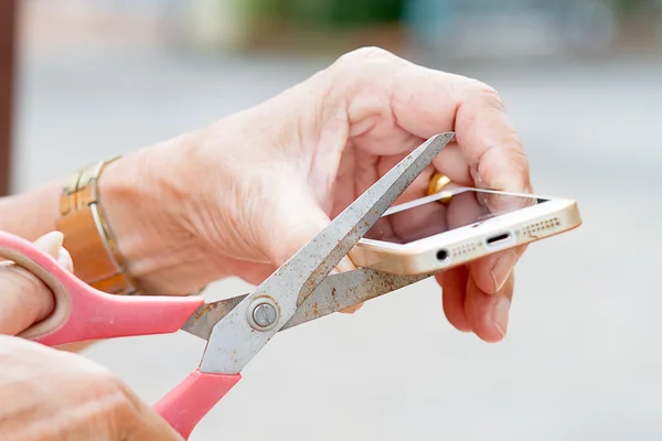 The old man's hand holding scissors and cut mobile phone. — Stock Photo, Image