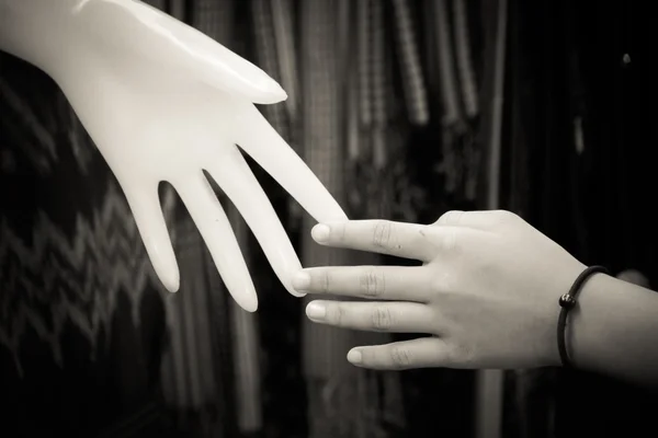 Концепция отношений: рука человека с пластиковой рукой — стоковое фото