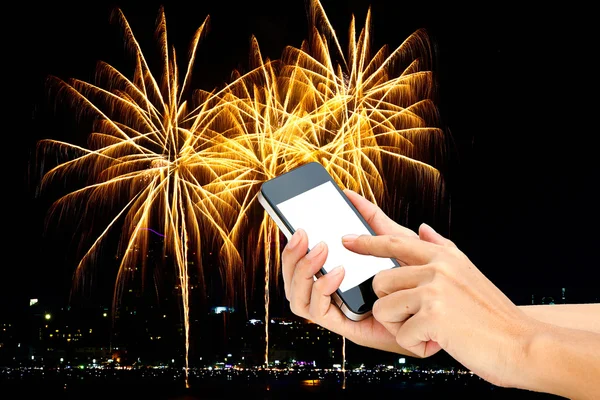 Genggam tangan layar sentuh pada telepon pintar atau telepon pada kembang api di t — Stok Foto