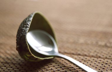 Masada kaşıkla avokado kabuğu yemiş.