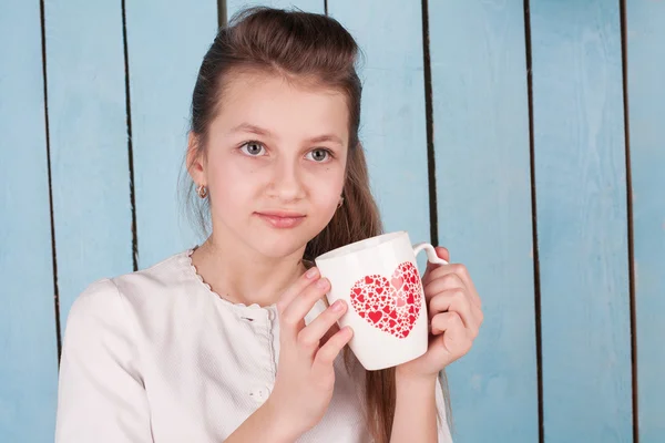 Beautiful young girl holding a cup — Stock Photo, Image