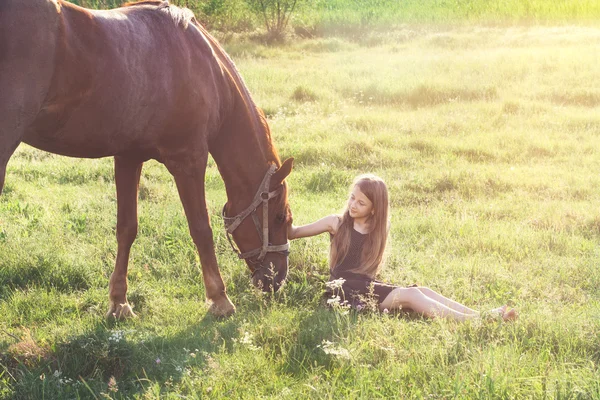 Девушка гладит свою лошадь — стоковое фото